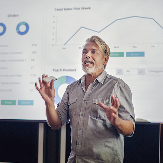 muž prezentuje před plátnem